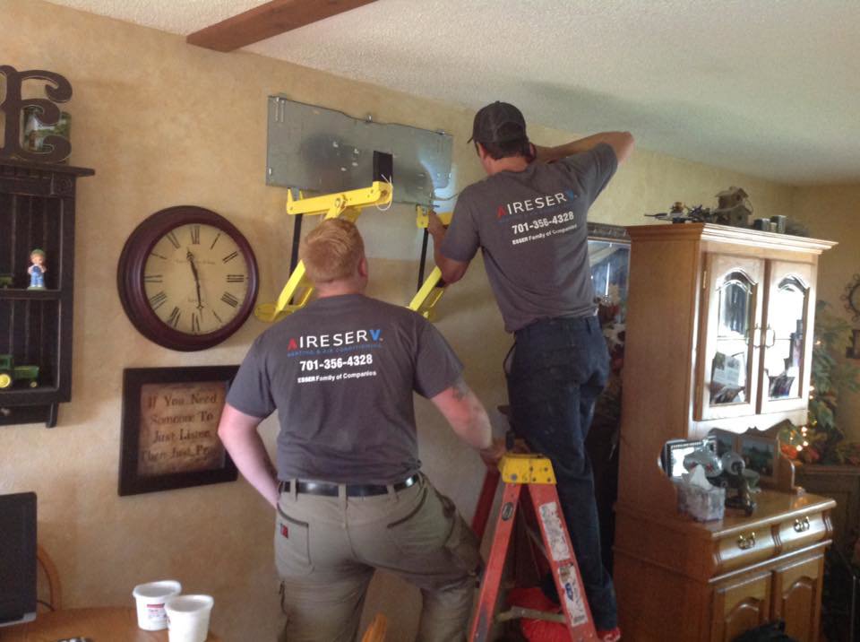 Aire Serv technicians installing an indoor mini-split HVAC unit in a home in West Fargo, ND.