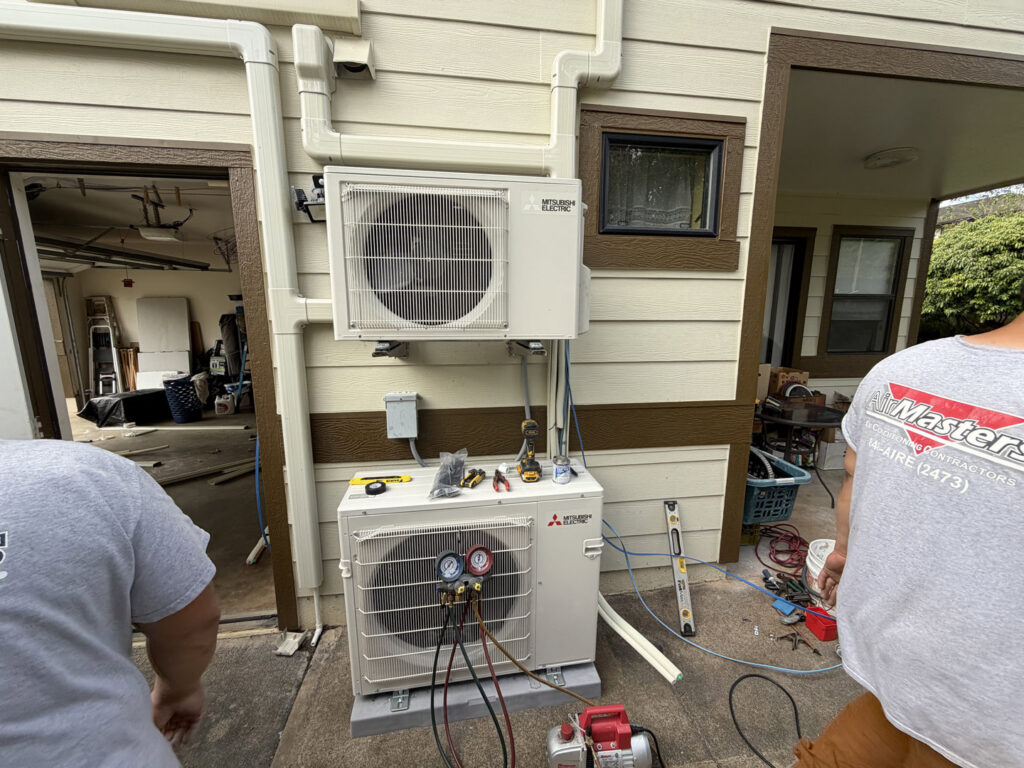 HVAC technicians installing a Mitsubishi Electric multi-zone outdoor unit for Air Masters, Inc. in Port Orchard, WA.