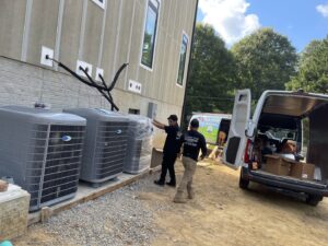 Vanessa Service HVAC technicians installing multiple outdoor air conditioning units at a new construction site in Falls Church, VA.