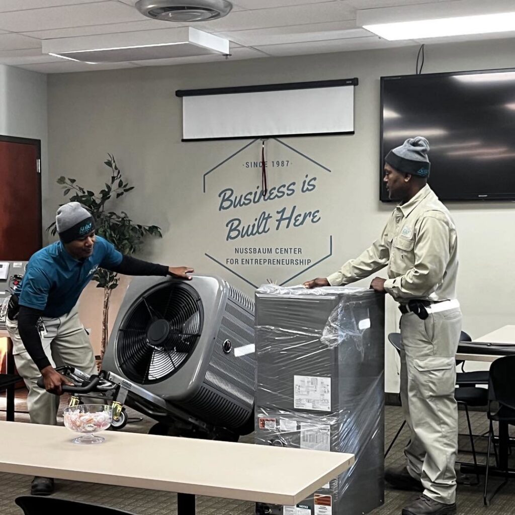 Two HVAC technicians installing new heating and cooling equipment for Relief Heating and Cooling, LLC in Greensboro, NC.