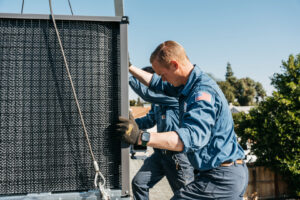 HVAC technicians installing a new outdoor unit, likely with crane assistance, for Controlled Climates Heating and Air Conditioning, Inc. in Fresno, CA.