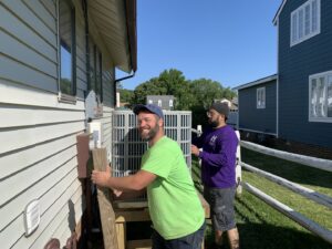 Hendrix Heating & Air technicians installing or servicing an outdoor air conditioning unit in Newport News, VA.