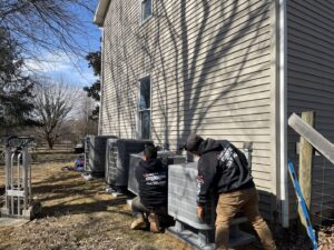 Vanessa Service HVAC technicians installing multiple outdoor air conditioning units at a residential property in Falls Church, VA.
