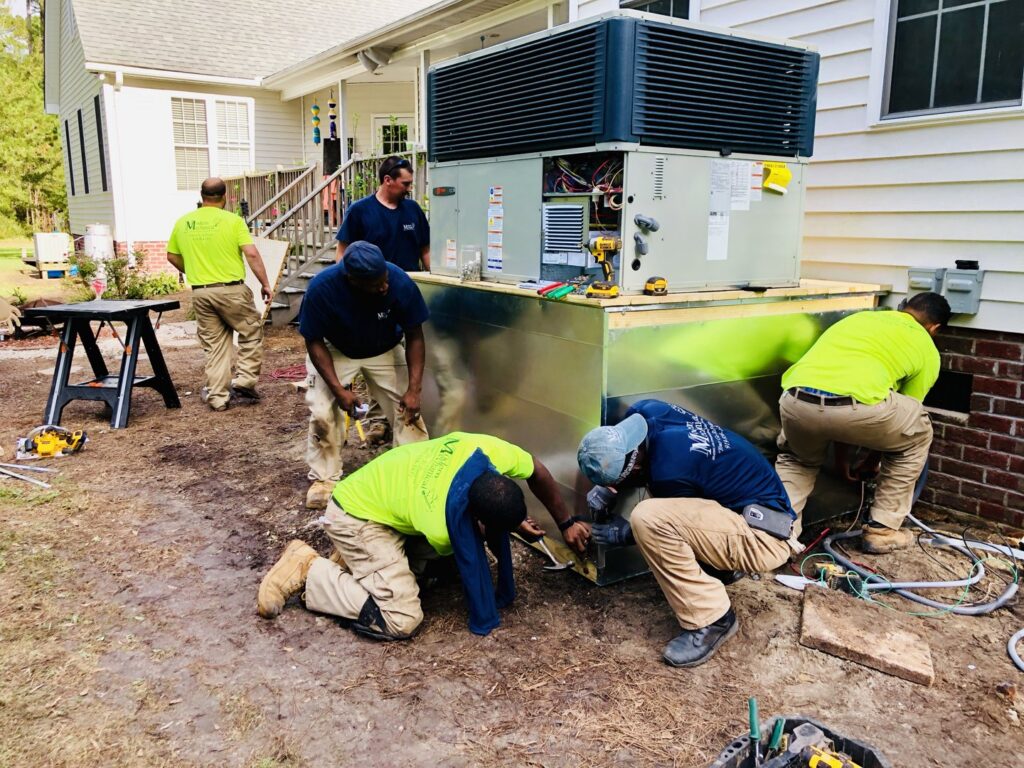 HVAC technicians installing an outdoor packaged unit, connecting ductwork and electrical for Modern Mechanical HVAC in Garner, NC.