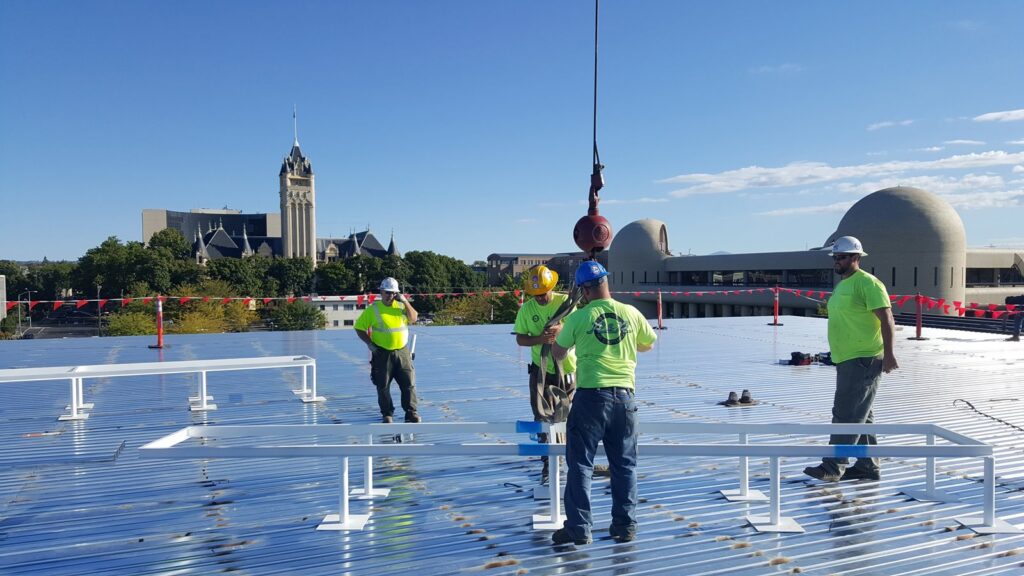 R&R Heating & Air Conditioning technicians installing metal frames for rooftop HVAC units in Spokane, WA.