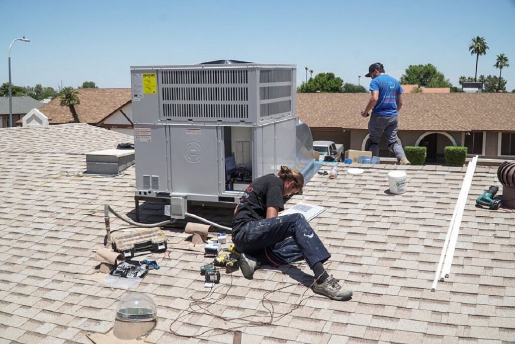 Two HVAC technicians installing a new rooftop unit for Diamond AC and Heating in Phoenix, AZ.