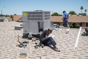 Two HVAC technicians installing a new rooftop unit for Diamond AC and Heating in Phoenix, AZ.
