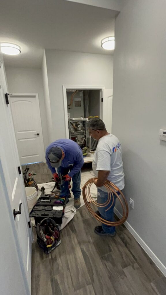 HVAC technicians installing a new system with copper tubing and tools for Bluestone Refrigeration LLC in Las Cruces, NM.