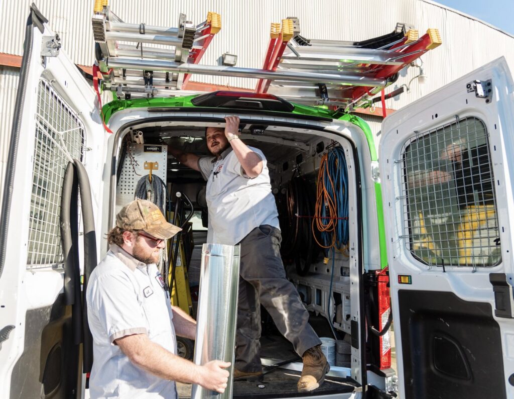 HVAC technicians from DFH Company Heating and Air Conditioning loading ductwork from a service van in Louisville, KY