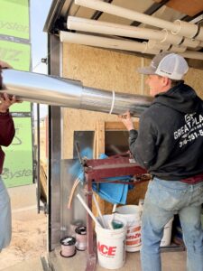 Great Plains Heating & Air technicians loading metal ductwork for an HVAC installation project in Goddard, KS.