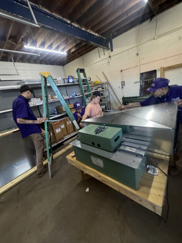 Milan Heating & Air technicians working together to fabricate sheet metal ductwork in Milan, TN.