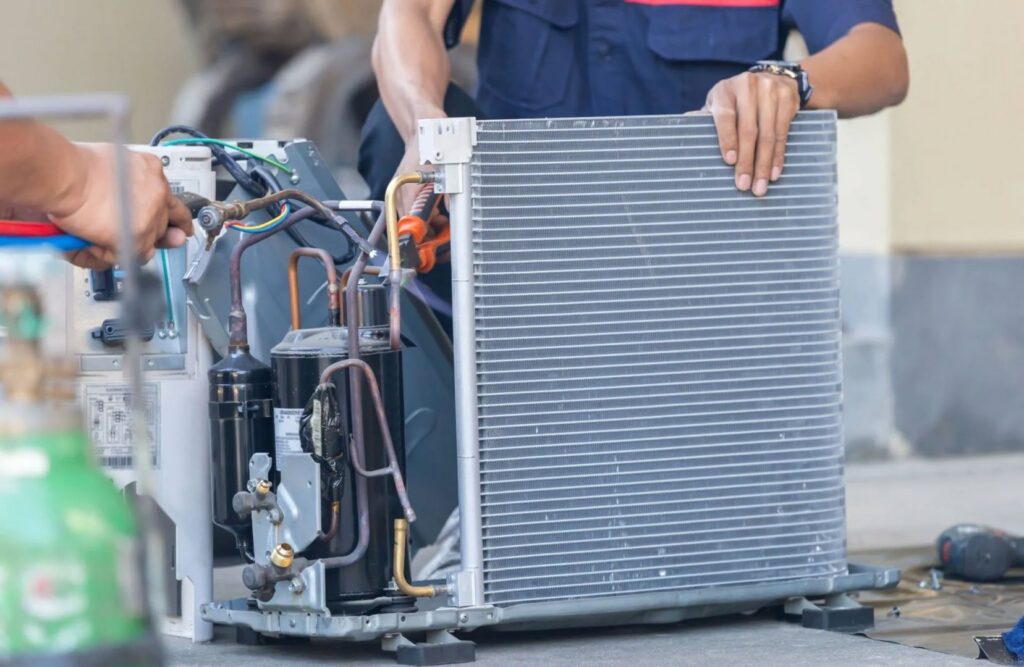 HVAC technicians repairing an open unit, exposing coils and compressor, for Ault's Cooling HVAC Services LLC in Chandler, AZ.