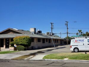 HVAC technicians performing rooftop service on multiple units for All Pro Air in Warrenville, IL.