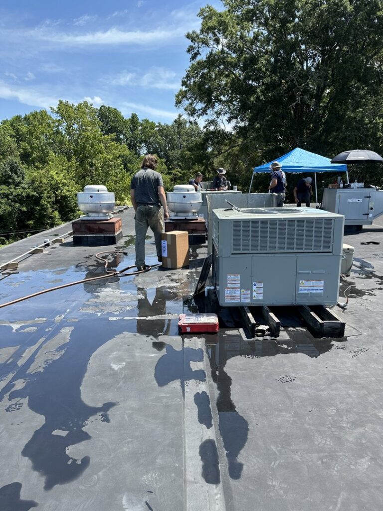 Infinite Comfort technicians installing a new rooftop HVAC unit in Youngsville, NC.