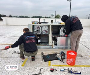 Two Empire Tech, Inc. technicians performing repair work on a commercial rooftop HVAC unit in Schaumburg, IL.