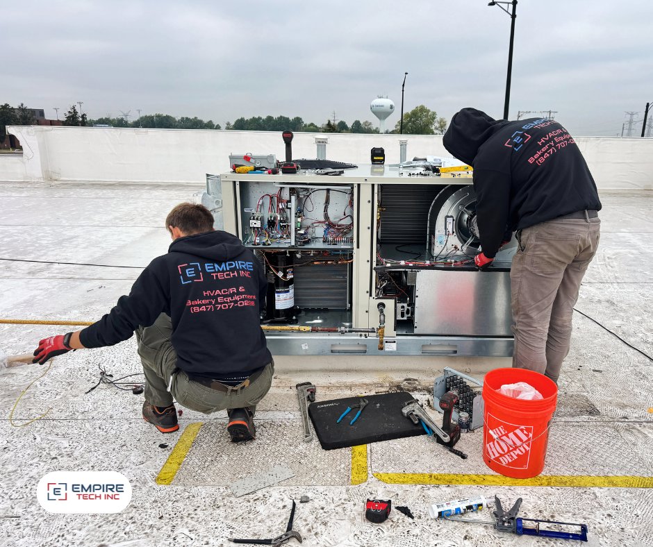 Two Empire Tech, Inc. technicians performing repair work on a commercial rooftop HVAC unit in Schaumburg, IL.