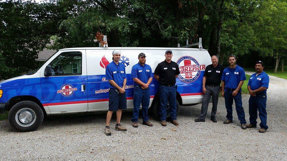 HVAC technicians standing with their service van for M.D. Repair Heating and Cooling in Oak Grove, MO.