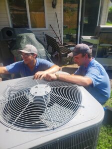 Two HVAC technicians servicing an outdoor air conditioning unit for Platinum Quality Air 500 in Hampton, VA.