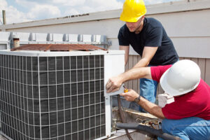 HVAC technicians in hard hats servicing a commercial outdoor unit for A&A HVAC and Electrical LLC in Nashville, TN.