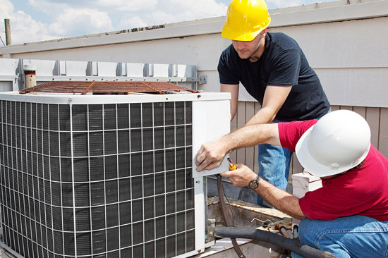 HVAC technicians in hard hats servicing a commercial outdoor unit for A&A HVAC and Electrical LLC in Nashville, TN.