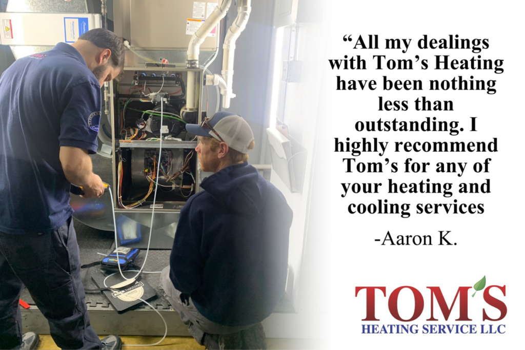 HVAC technicians servicing a furnace at a customer's home by Tom's Heating Service in Waukesha, WI.