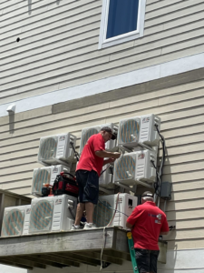 HVAC technicians servicing multiple outdoor mini-split AC units for Spartan Air Conditioning in McIntosh, AL.