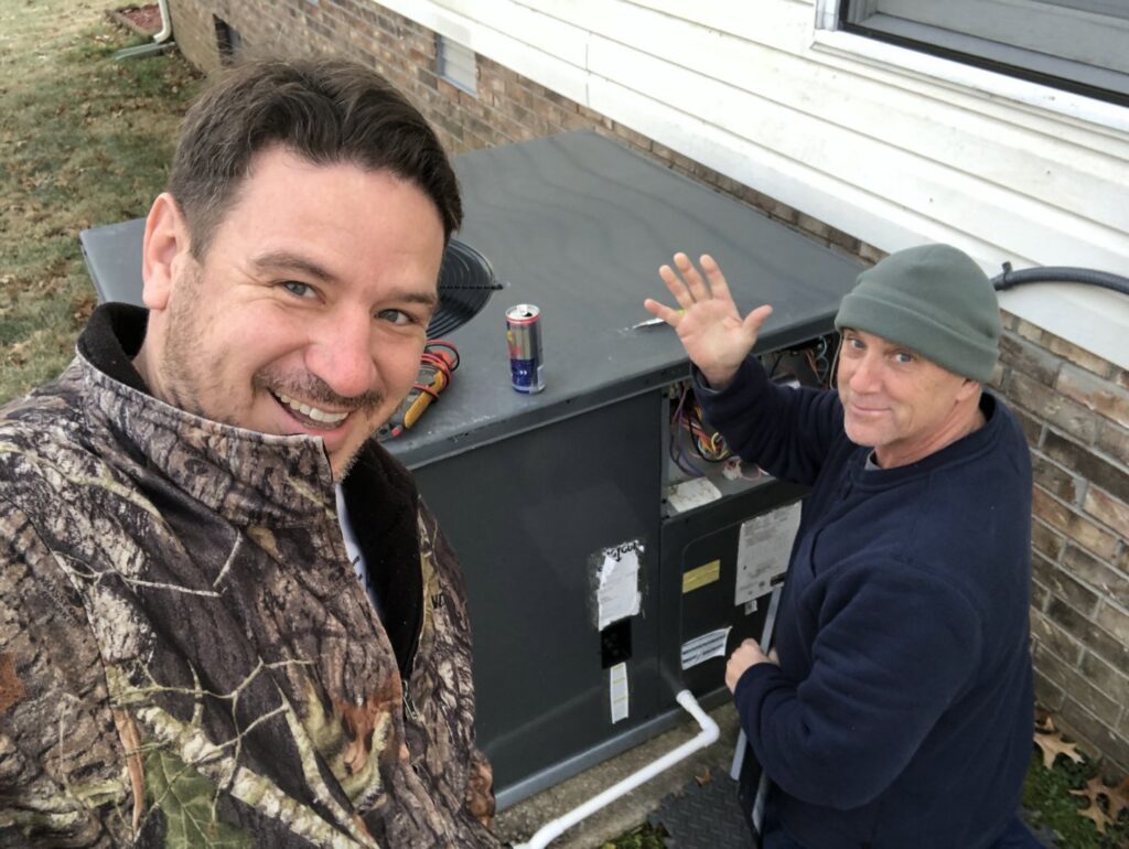 Two HVAC technicians servicing an outdoor air conditioning unit for Eaton Companies LLC in Clarksville, TN.