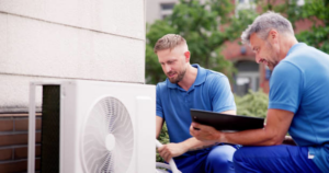 Two HVAC technicians from Texas Air Authorities, Inc. servicing an outdoor air conditioning unit in Arlington, TX.