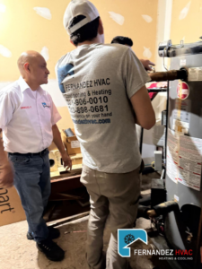 Two HVAC technicians from Fernandez HVAC servicing a water heater in Alexandria, VA.