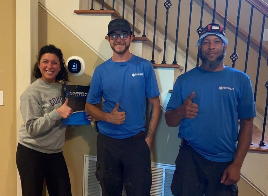 HVAC technicians from Conditioned Air Solutions giving thumbs up after a successful job for Leap Partners in Greensboro, NC.