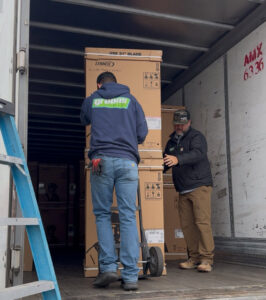 Two HVAC technicians from Greens Heating & Air Conditioning unloading new Lennox equipment in Douglasville, GA.