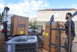 HVAC technicians unloading new condenser units and equipment for installation by Diamond AC and Heating in Phoenix, AZ.
