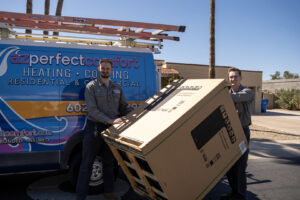 Two HVAC technicians unloading a new air conditioning unit from a company van for AZ Perfect Comfort in Phoenix, AZ.