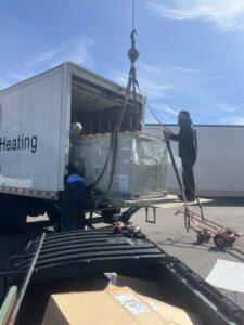 HVAC technicians from HVAC Philly carefully unloading a new HVAC unit from a delivery truck in Feasterville, PA.