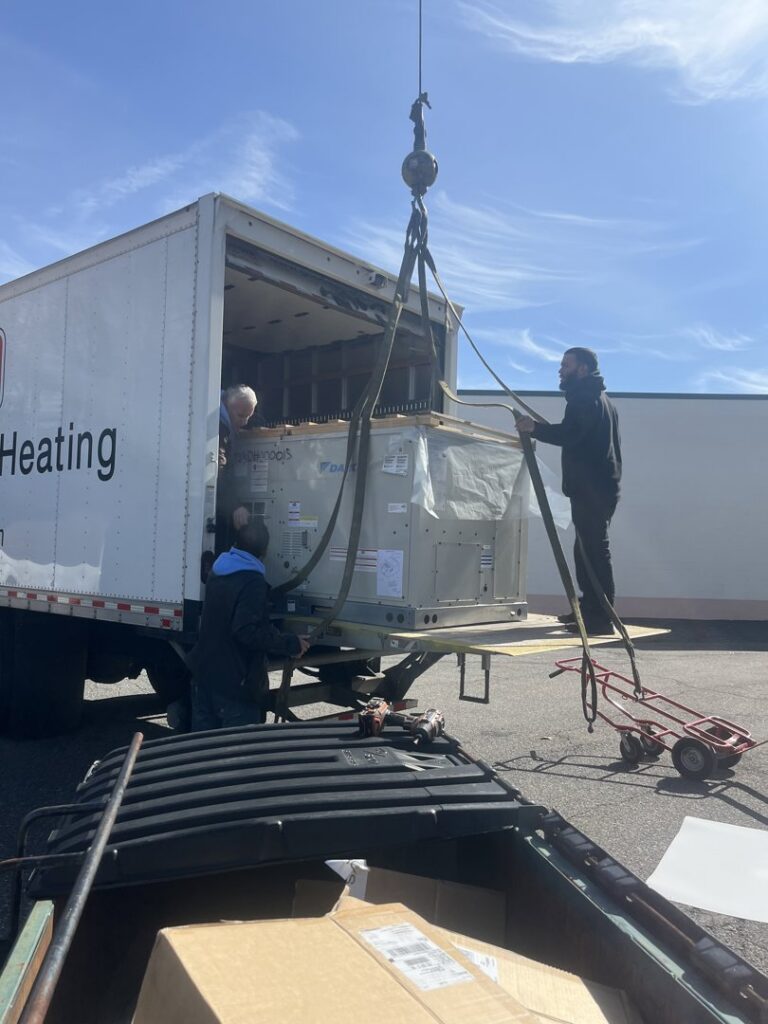 HVAC technicians from HVAC Philly carefully unloading a new HVAC unit from a delivery truck in Feasterville, PA.