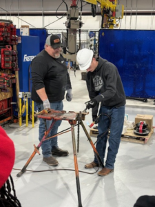 HVAC technicians welding and fitting pipes in a workshop at QuesTec in Columbia, MO