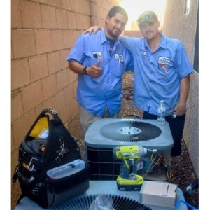 Two HVAC technicians from Bishop Air Service standing with an outdoor AC unit and tools in Henderson, NV.