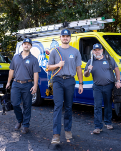 HVAC technicians with tools standing in front of a service van for Powell's of Wilmington, NC