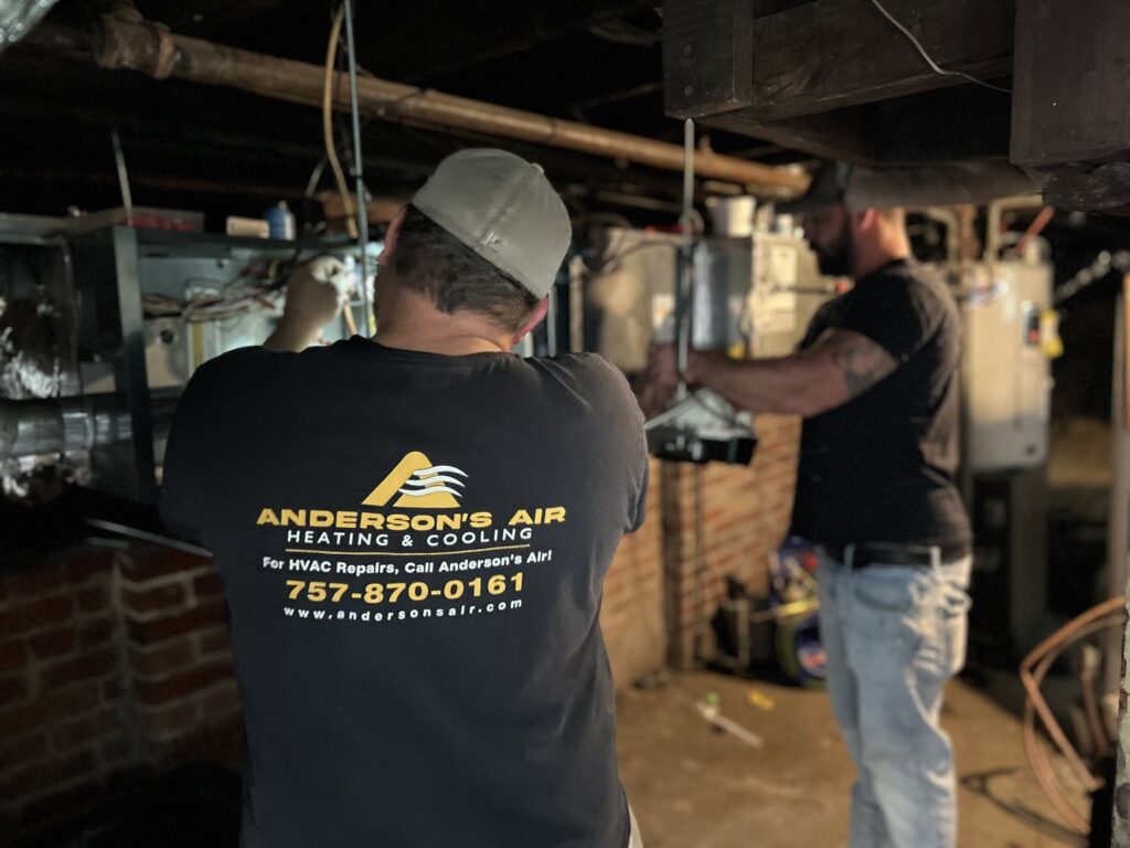 Two HVAC technicians working on heating and cooling equipment for Anderson's Air in Newport News, VA