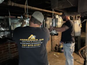 Two HVAC technicians working on heating and cooling equipment for Anderson's Air in Newport News, VA