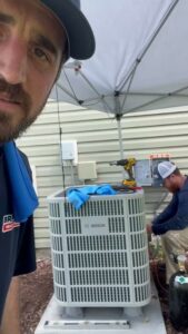 HVAC technicians from Brand Air Heating and Cooling LLC performing service on an outdoor AC unit in Wilmington, NC.