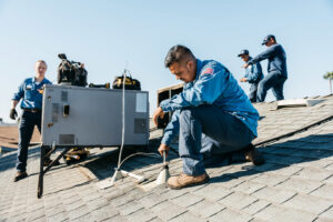 Multiple HVAC technicians working on a rooftop air conditioning unit for Controlled Climates Heating and Air Conditioning, Inc. in Fresno, CA.