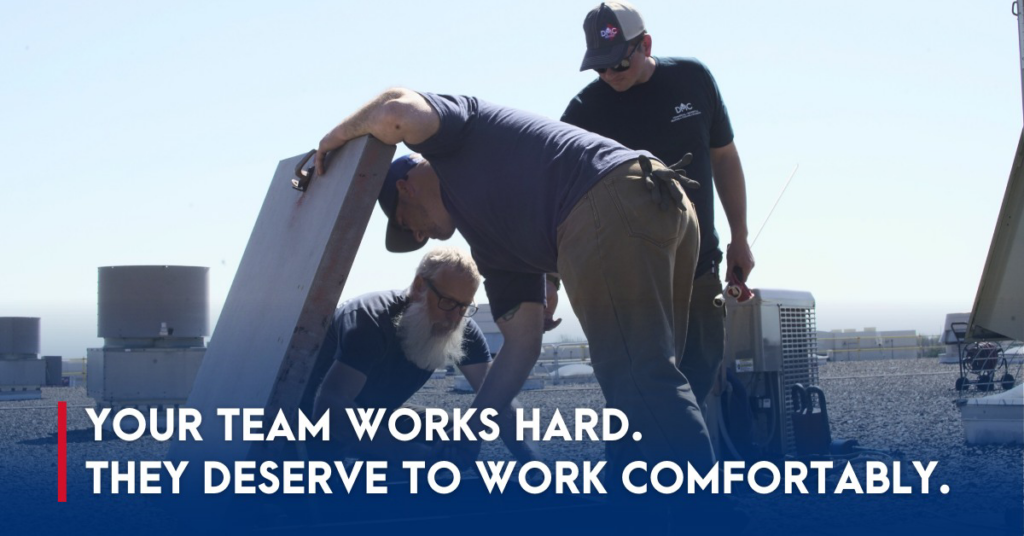 HVAC technicians from DMC Service, Inc. working on a rooftop unit with other HVAC equipment visible in Olathe, KS.