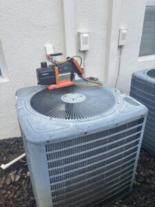 HVAC vacuum pump and tools on top of an outdoor AC unit during service by Air Support Cooling and Heating, LLC in Tampa, FL