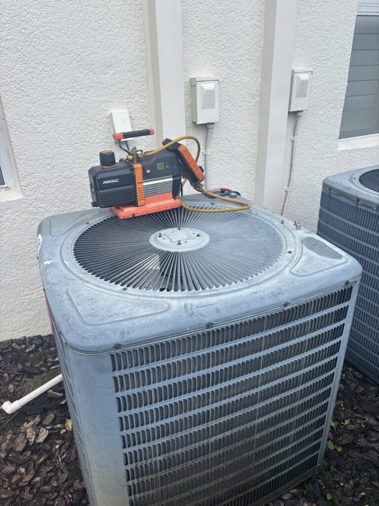 HVAC vacuum pump and tools on top of an outdoor AC unit during service by Air Support Cooling and Heating, LLC in Tampa, FL