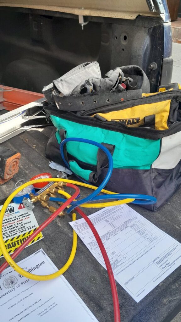HVAC tools, including a manifold gauge set and tool bag, on the back of a service truck for PNW Spokane Heating and Air in Spokane, WA.
