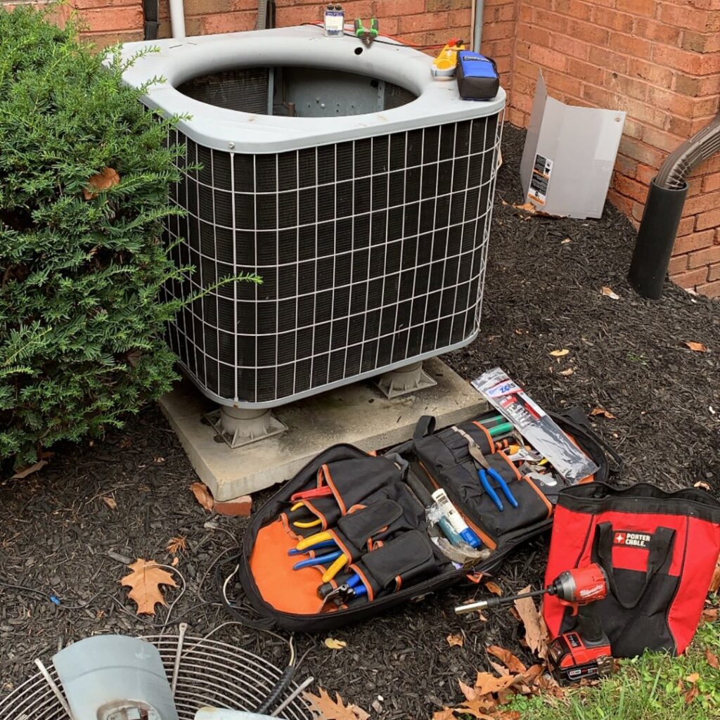 HVAC tools and equipment laid out next to an outdoor air conditioning unit for service by PureAir HVAC in Bel Air, MD.