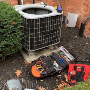 HVAC tools and equipment laid out next to an outdoor air conditioning unit for service by PureAir HVAC in Bel Air, MD.