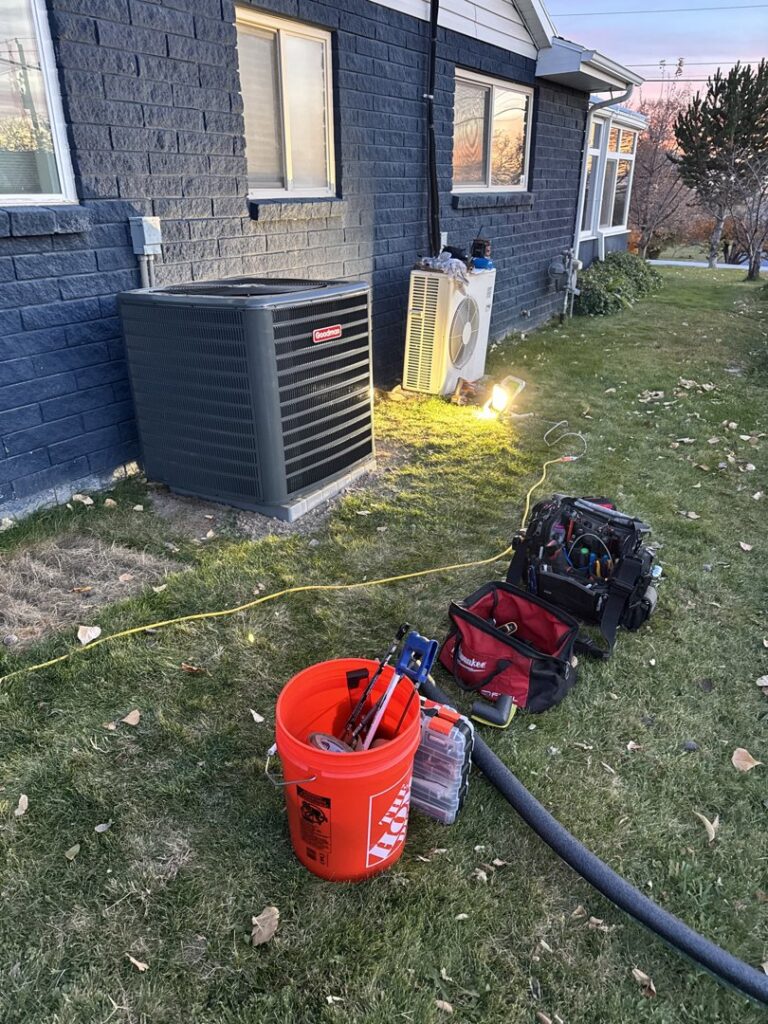 HVAC tools and equipment laid out next to an outdoor AC unit during service by LeoAir, LLC in West Jordan, UT.