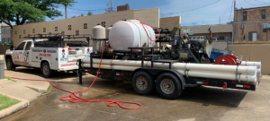 An HVAC service truck and trailer loaded with geothermal pipes and equipment for Environmental Loop Service in Tulsa, OK.